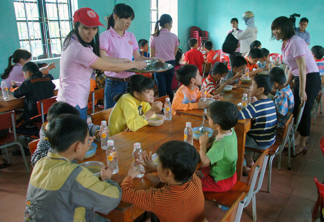 Cán bộ, nhân viên Công ty Cổ phần Chăn nuôi CP Việt Nam tự tay nấu cháo cho trẻ em khuyết tật ăn sáng.