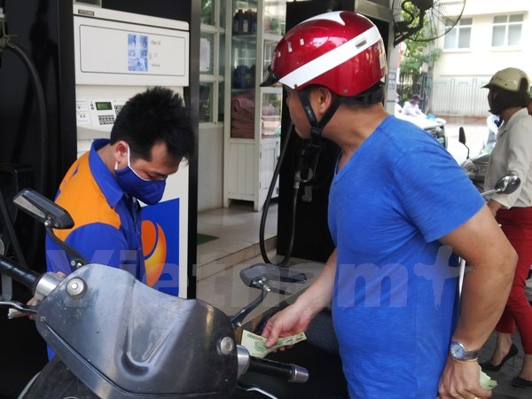 Nhân viên Petrolimex đang bơm xăng cho khách hàng (Ảnh: Đức Duy/Vietnam+)