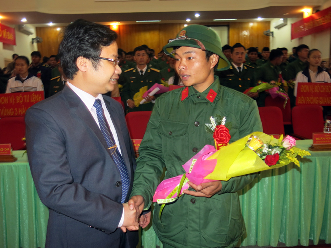 Đồng chí Trưởng ban Tuyên giáo Tỉnh ủy tặng hoa và căn dặn, động viên tân binh huyện Minh Hóa.