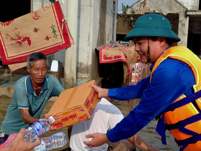 Đồng chí Trần Quốc Tuấn, Bí thư Tỉnh Đoàn trao quà cho bà con nhân dân thôn Hữu Tân, xã Tân Ninh, huyện Quảng Ninh.