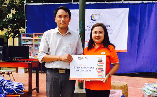 Đại diện lãnh đạo công đoàn FPT tặng máy tính và tủ sách cho trường THCS Sơn Trạch