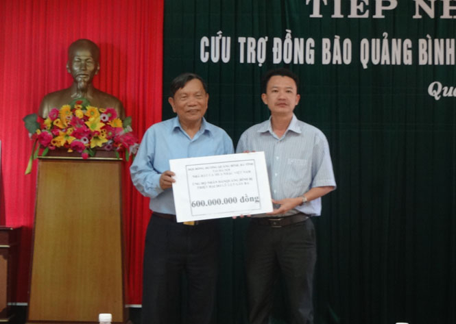Đại diện Hội đồng hương Quảng Bình, Hà Tĩnh tại Hà Nội trao số tiền hỗ trợ người dân vùng lũ Quảng Bình cho đại diện Ban Cứu trợ tỉnh