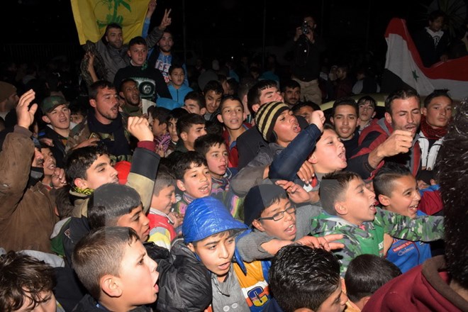 Người dân Syria vui mừng sau khi quận Mogambo của thành phố Aleppo được giải phóng ngày 12-12. (Nguồn: AFP/TTXVN)