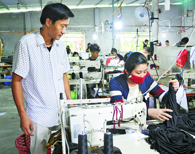  Lê Văn Lập đang hướng dẫn các thợ may.