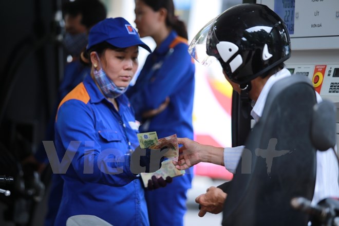 Nhân viên Petrolimex đang bán xăng cho khách hàng. (Ảnh: Đức Duy/Vietnam+)