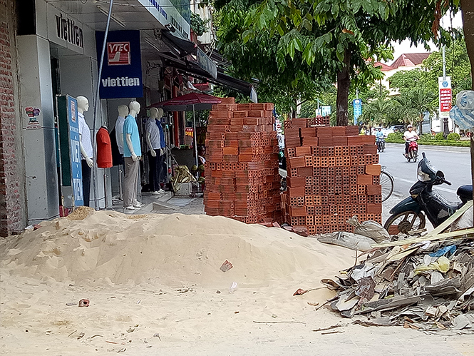Tập kết vật liệu xây dựng lấn chiếm hết vỉa hè đường Trần Hưng Đạo.