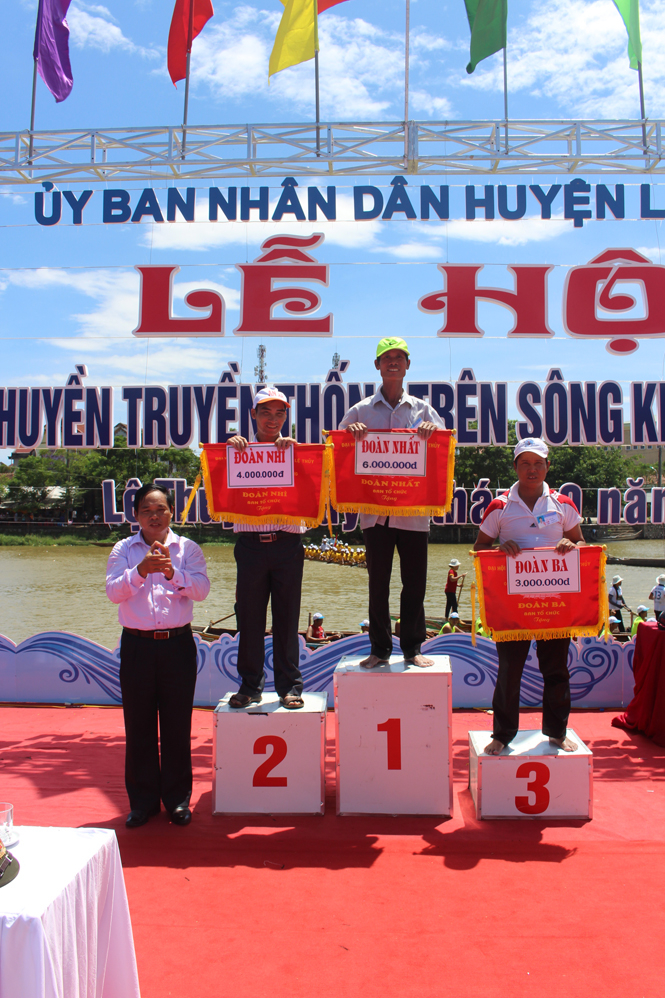 Đồng chí Nguyễn Quang Năm, Bí thư Huyện ủy, Chủ tịch HĐND huyện trao giải Nhất, Nhì, Ba toàn đoàn cho các đội đua, bơi.