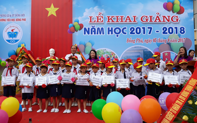 Đại diễn các nhà hảo tâm và Ban giám hiệu nhà trường tặng quà cho các em học sinh.