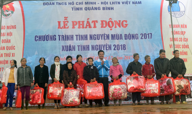 Đồng chí Trần Quốc Tuấn, Bí thư Tỉnh Đoàn trao quà cho các em học sinh Trường Tiểu học và THCS xã Xuân Hóa.