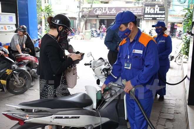 Nhân viên Petrolimex đang bán xăng cho khách hàng. (Ảnh: Đức Duy/Vietnam+)