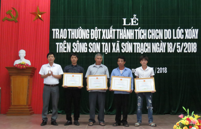Đồng chí Mai Xuân Toàn, Trưởng Ban Thi đua - Khen thưởng tỉnh trao Bằng khen của Chủ tịch UBND tỉnh cho 4 cá nhân ở xã Sơn Trạch đã dũng cảm cứu du khách trong trận lốc xoáy trên sông Son ngày 18-5-2018.