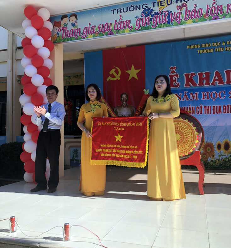 Đồng chí Lê Văn Phúc, Ủy viên Ban Thường vụ Tỉnh ủy, Bí thư thành ủy Đồng Hới trao Cờ thi đua xuất sắc dẫn đầu cấp học cho trường Tiểu học Lộc Ninh (TP. Đồng Hới).