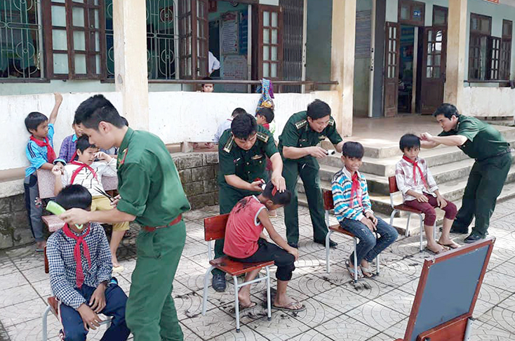 Cán bộ, chiến sỹ Đồn Biên phòng Làng Ho cắt tóc cho con em dân bản.