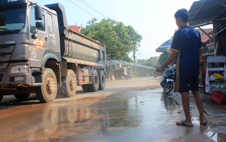 Người dân phải thường xuyên tưới nước để giảm bớt bụi.