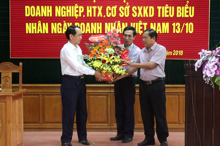 Đồng chí Phan Mạnh Hùng, Bí thư Huyện ủy Quảng Ninh tặng hoa chúc mừng các doanh nghiệp nhân ngày Doanh nhân Việt Nam.