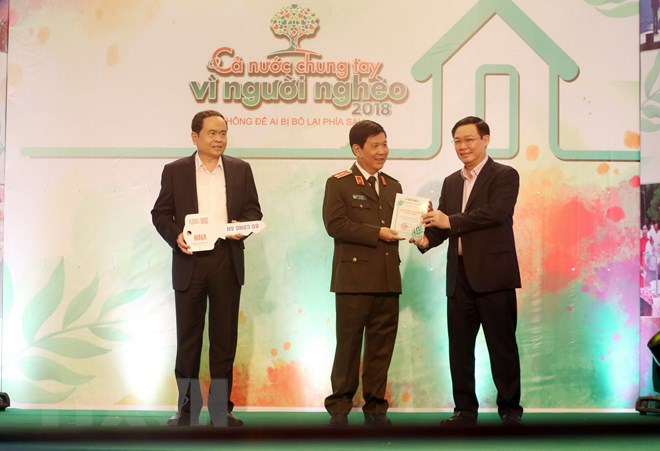 Phó Thủ tướng Vương Đình Huệ trao Kỷ niệm chương; Chủ tịch Ủy ban Trung ương Mặt trận Tổ quốc Việt Nam Trần Thanh Mẫn nhận ủng hộ từ các doanh nghiệp, tổ chức, cá nhân đóng góp giúp đỡ người nghèo. (Ảnh: Anh Tuấn/TTXVN)