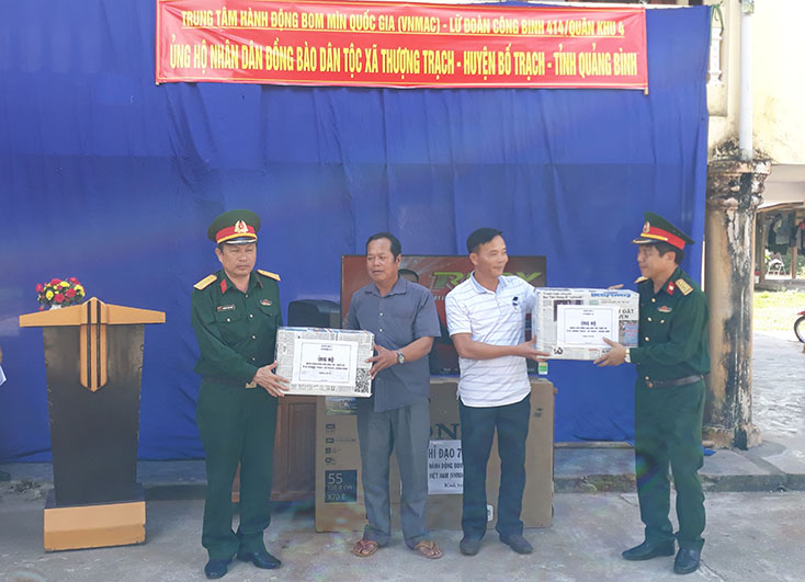 Đại diện lãnh đạo Lữ đoàn công binh 414 Quân khu 4 tặng quà cho chính quyền xã Thượng Trạch.