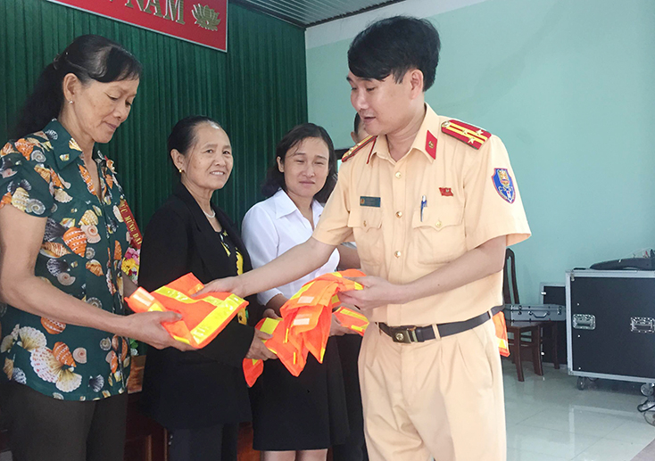 Đại diện Phòng CSGT, Công an tỉnh phát áo phản quang cho người dân.