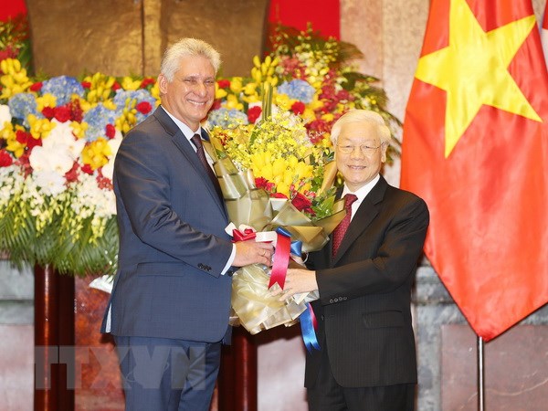 Tổng Bí thư, Chủ tịch nước Nguyễn Phú Trọng tặng hoa chúc mừng Chủ tịch Hội đồng Nhà nước và Hội đồng Bộ trưởng Cuba Miguel Mario Diáz-Canel Bermúdez nhận phần thưởng cao quý của Đảng, Nhà nước Việt Nam. (Ảnh: Trí Dũng/TTXVN)