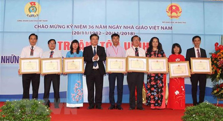 Thứ trưởng Bộ Giáo dục và Đào tạo Nguyễn Hữu Độ tặng Bằng khen của Bộ trưởng Bộ Giáo dục và Đào tạo cho các nhà giáo tiêu biểu. (Ảnh: Thanh Tùng/TTXVN)