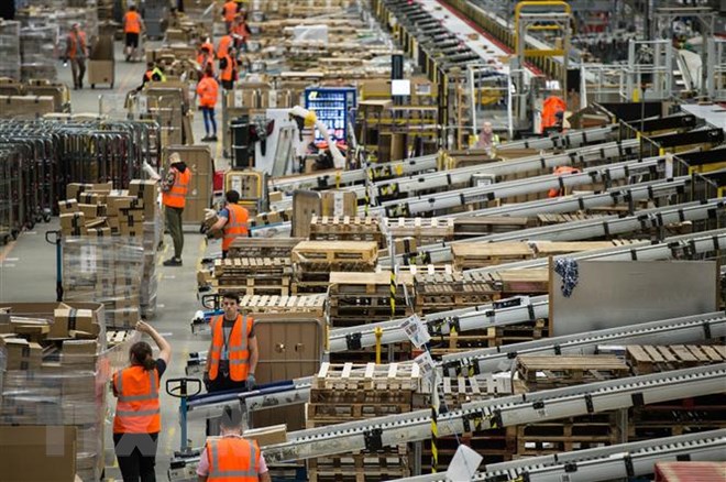 Công nhân làm việc tại một trung tâm dịch vụ ở Peterborough, miền Trung Anh. (Ảnh: AFP/ TTXVN)