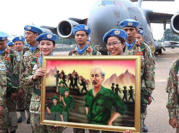 Các sỹ quan, chiến sỹ quân y mang theo bức tranh Bác vẫn cùng chúng cháu hành quân lên đường nhận nhiệm vụ. (Ảnh: Xuân Khu/TTXVN)