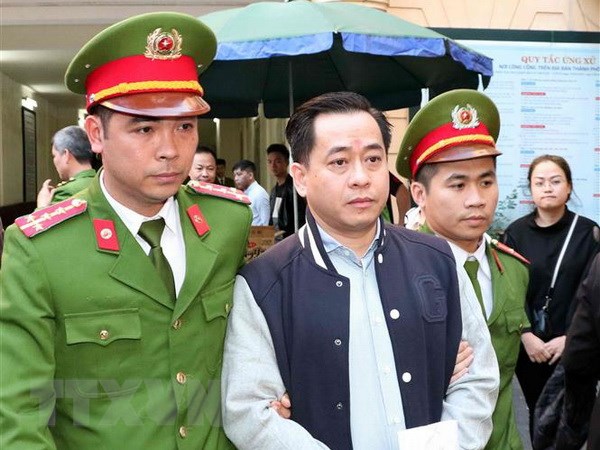 Cảnh sát dẫn giải bị cáo Phan Văn Anh Vũ sau khi Hội đồng xét xử kết thúc tuyên án. (Ảnh: Văn Điệp/TTXVN)