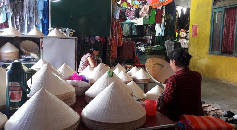 Sắc trắng của nón làm nổi bật cả một góc chợ quê.