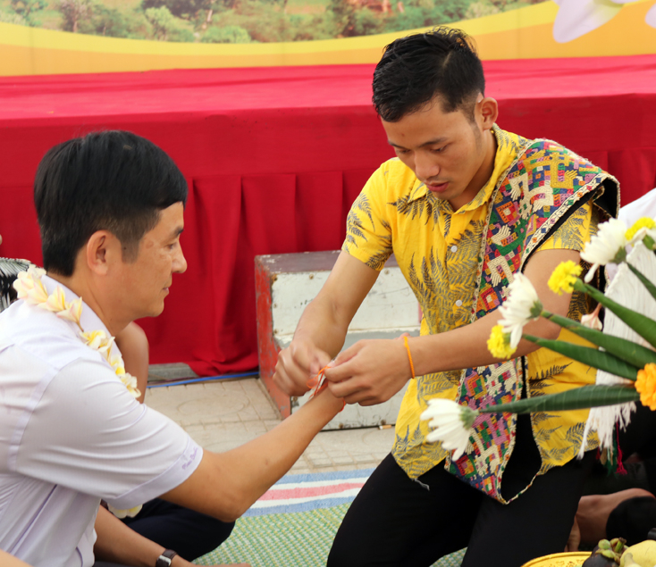  Trao nhau sợi chỉ buộc cổ tay.