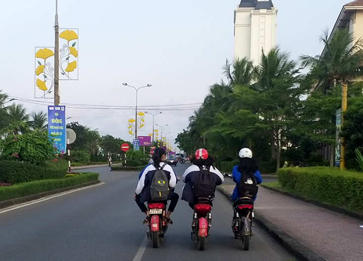Điều khiển xe đạp điện dàn hàng ngang, không đội mũ bảo hiểm, những lỗi vi phạm khá phổ biến của các em học sinh.