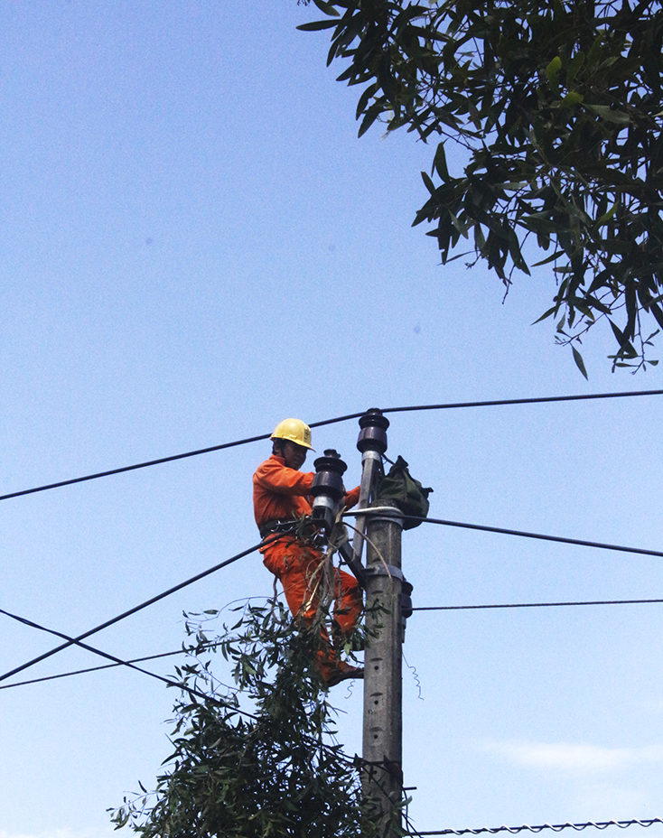 Công nhân Điện lực Minh Hóa thi công lắp chụp cột lưới điện cao áp.