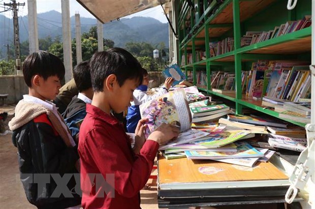 Các em học sinh vùng cao Sơn La được tiếp cận với nhiều loại sách báo bổ ích thông qua xe thư viện lưu động. (Ảnh: Hữu Quyết/TTXVN)
