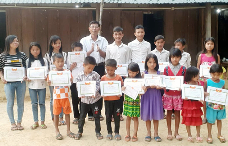 Thầy Hoàng Văn Sáu trao giấy khen cho học sinh của điểm trường bản Đoòng nhân dịp tổng kết năm học 2018-2019.
