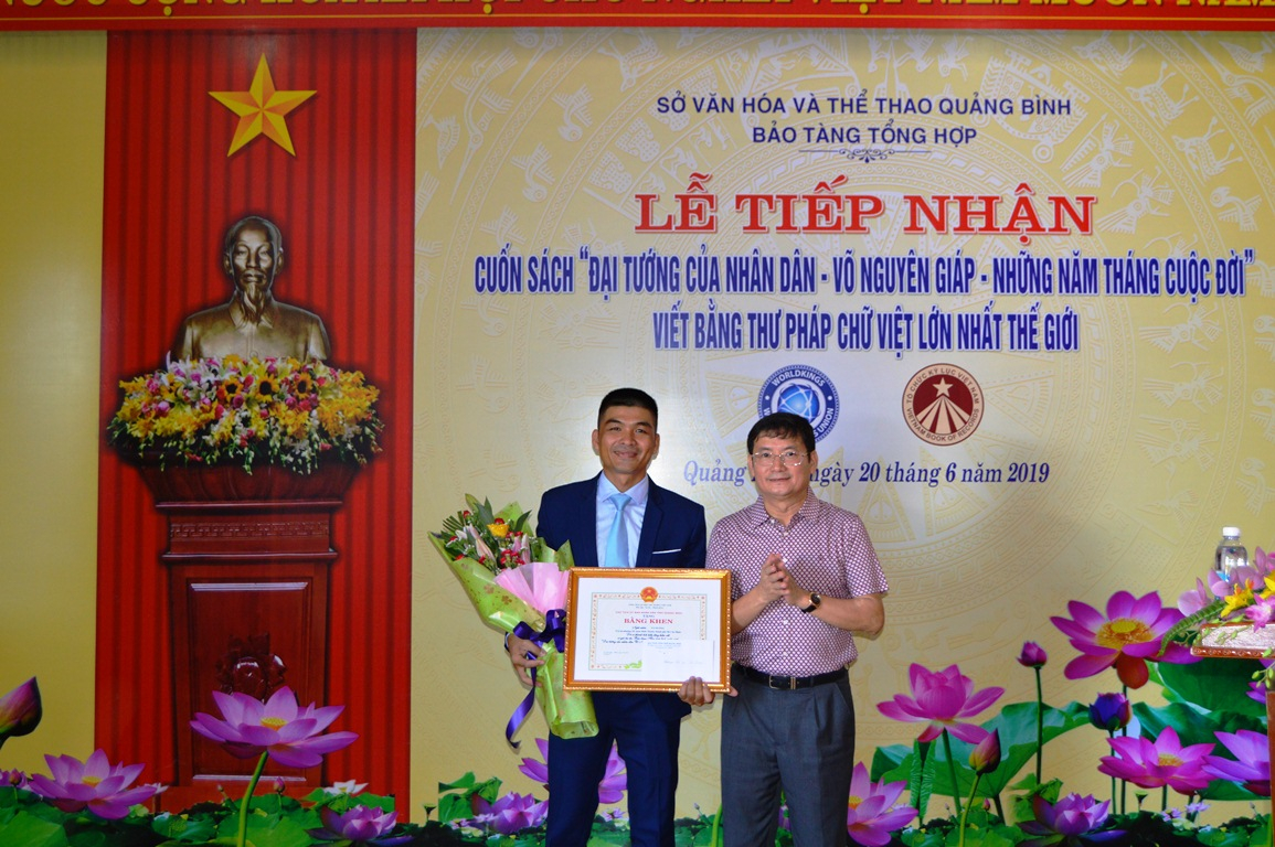 Đồng chí Phó Chủ tịch UBND tỉnh Trần Tiến Dũng trao Bằng khen của UBND tỉnh cho kỷ lục gia, nghệ nhân thư pháp Võ Dương.