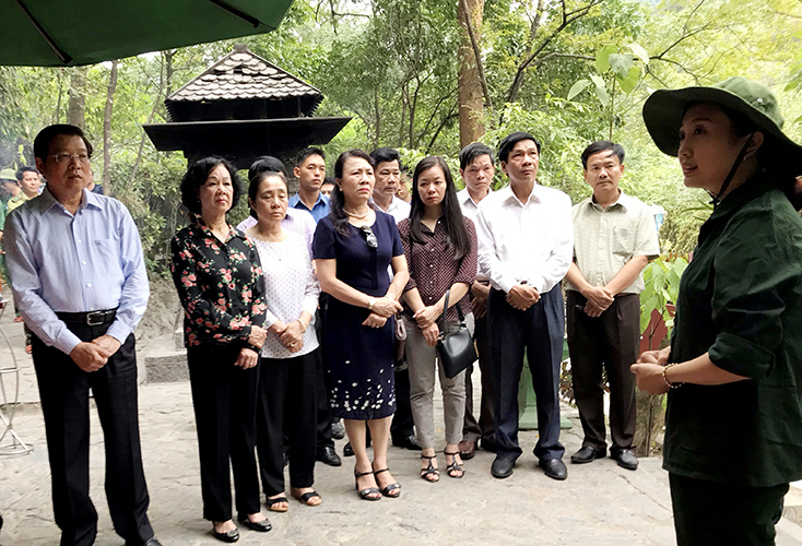 Đoàn công tác nghe giới thiệu về lịch sử hang 8 Thanh niên xung phong.