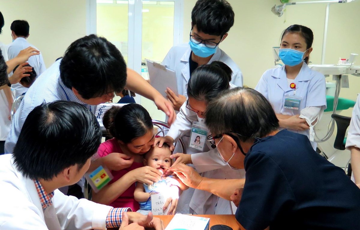 Các giáo sư, bác sỹ khám, điều trị và phẫu thuật miễn phí cho trẻ em bị sứt môi, hở hàm ếch, sẹo xấu ở mũi, khe hở ngang mặt. (Ảnh: Tường Vi/TTXVN)