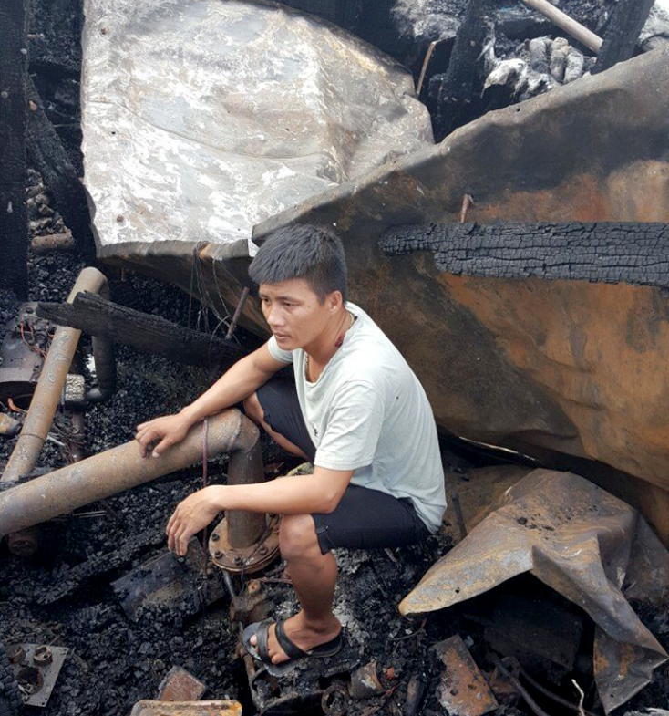 Ông Hiếu thẫn thờ trên con tàu đánh cá bị cháy.