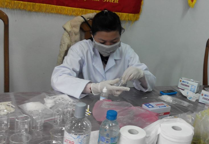 Cán bộ y tế đang thực hiện kiểm nghiệm mẫu thực phẩm bằng phương pháp test nhanh