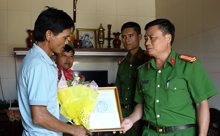 Thượng tá Lê Văn Hóa, Trưởng Công an TX. Ba Đồn trao thư khen, tặng hoa anh Hoàng Văn Hóa.