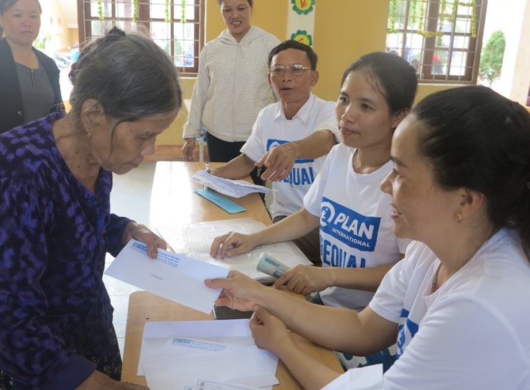 Cán bộ, nhân viên Văn phòng Dự án Plan tỉnh Quảng Bình trao quà cho người dân xã Minh Hóa, huyện Minh Hóa  
