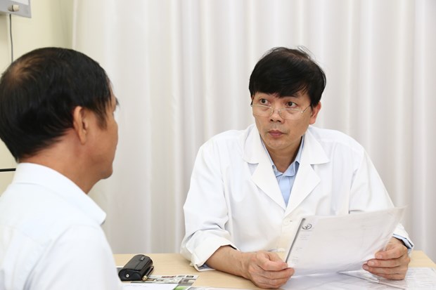  Phó giáo sư Nguyễn Xuân Hùng khám cho bệnh nhân. (Ảnh: PV/Vietnam+)