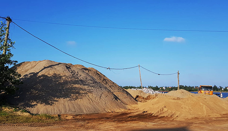 Bãi tập kết cát, sỏi của ông Lương với những núi cát cao ngất ngưởng hơn trước khi bị yêu cầu chấm dứt hoạt động.
