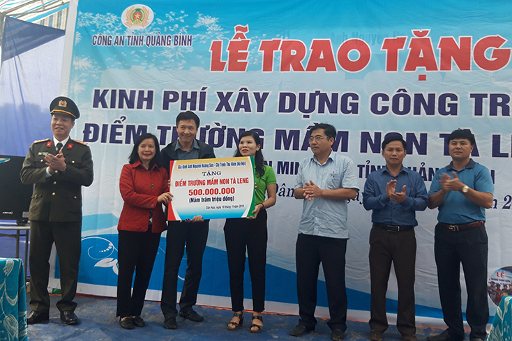 Đại tá Trần Hải Quân, Giám đốc Công an tỉnh và gia đình anh Nguyễn Hoàng Sơn, chị Trịnh Thu Hiền trao tặng kinh phí xây dựng trường mầm non bản Tà Leeng, xã Dân Hóa, huyện Minh Hóa