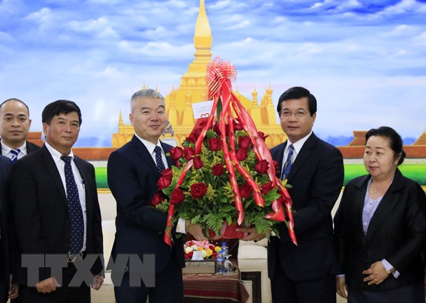 Đại biện Nguyễn Thanh Tùng chúc mừng Phó Trưởng Ban Đối ngoại Trung ương Lào Somphone Sichaleun. (Ảnh: Phạm Kiên/TTXVN)