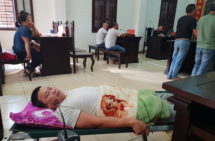 Bị cáo Phạm Thế Nhân bị thương không thể đứng được, HĐXX cho phép bị cáo được nằm trên giường trong quá trình tham gia tố tụng