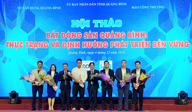 Đại diện lãnh đạo Sở Xây dựng, Cục Quản lý nhà và thị trường BĐS Bộ Xây dựng tặng hoa cho các đơn vị tài trợ tổ chức hội thảo.