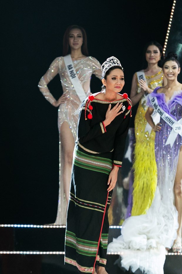 Hoa hậu H’Hen Niê xuất hiện với đôi chân trần và trang phục Êđê, đội vương miện trong màn Final Walk trước khi trao lại danh hiệu cho người kế vị tiếp theo. (Ảnh: Sang Đào/Vietnam+)