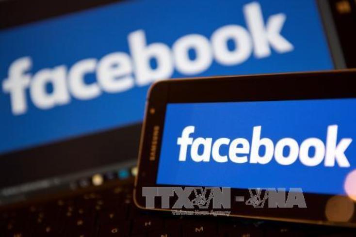 Biểu tượng Facebook trên màn hình điện thoại và máy tính. Ảnh: AFP/TTXVN