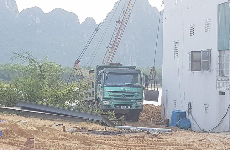 Một bãi tập kết cát trái phép lắp đặt cả cần cẩu cố định cỡ lớn để múc cát lên xe ô tô vận chuyển đi tiêu thụ.