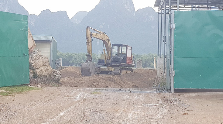 Một bãi tập kết cát trái phép được che chắn bên ngoài, chỉ được mở ra khi có xe vào ra lấy cát.